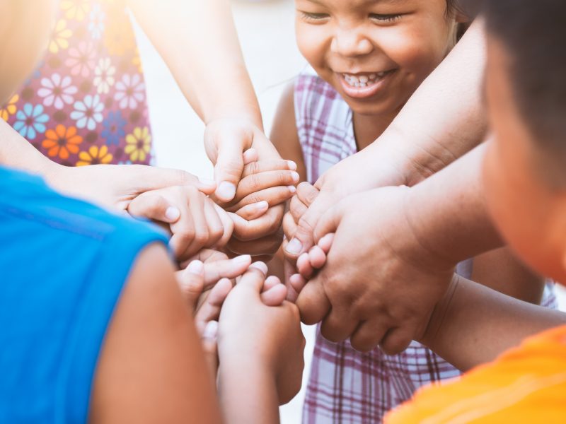 Children and parent holding hands and playing together with unit Children and parent holding hands and playing together with unity and teamwork